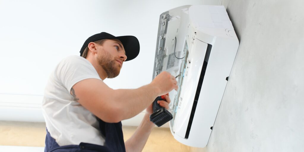 Best HVAC Company in Brentwood, TN - Man fixing an AC unit in home